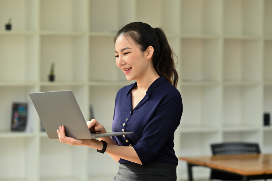 Professional using a laptop to manage email marketing campaigns in a modern office