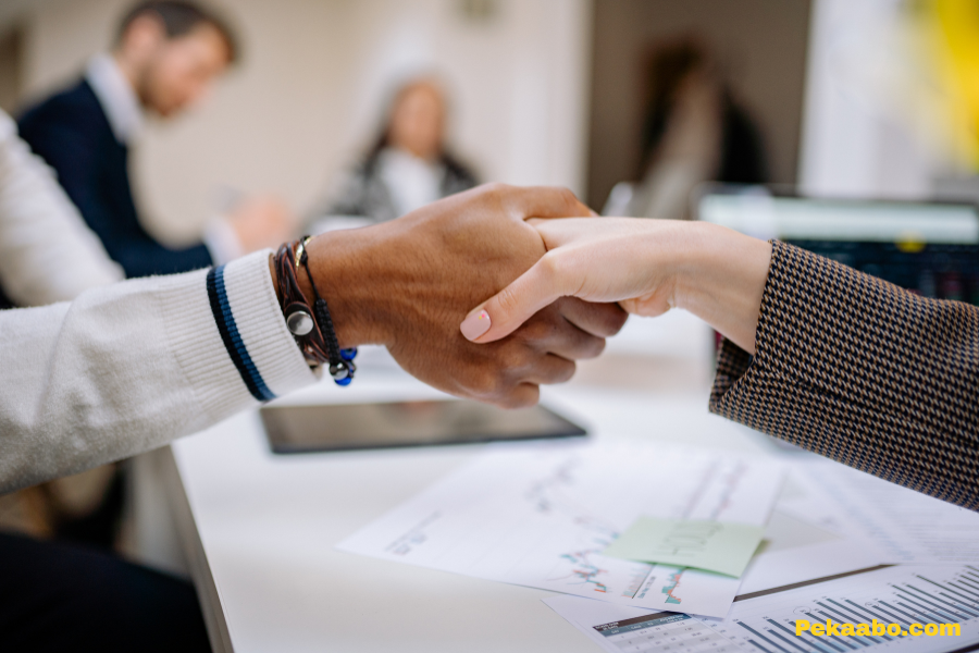 Growth Marketing Services for B2B Companies: What to Include 2 B2B professionals shaking hands after discussing growth marketing services and business strategy.